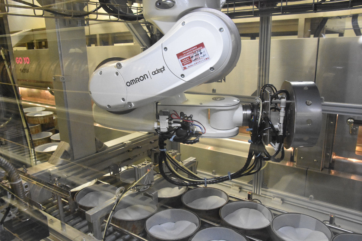 焼き型にクッキングシートを敷く工程をロボットに担わせている